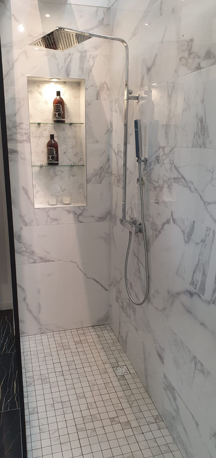 Douche à l'italienne terminée en marbre blanc avec niche